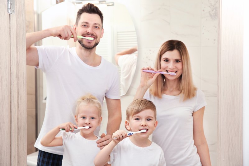 young-couple-their-children-brushing-teeth-bathroom